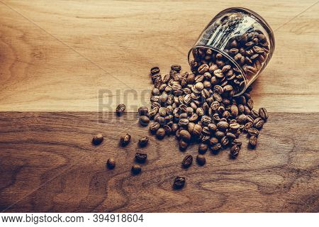 Coffee Beans In A Coffee Cup On Wooden Table. Top View Of Medium Roasted Coffee Beans For Coffee Dri