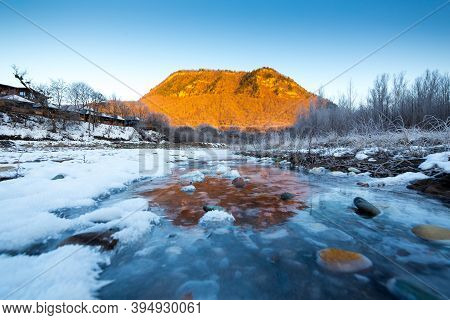 Beautiful Sunny Winter Landscape With Ice River And The Mountain.