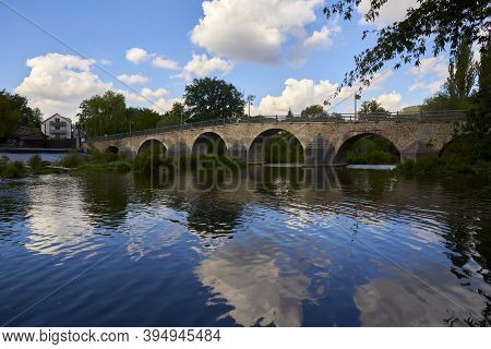 Beautiful Old Bridge Over A Calm River On A Sunny Day