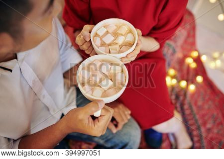 Two Big Mugs Of Sweet Delicious Hot Chocolate With Marshmallows In Hands Of Young Couple