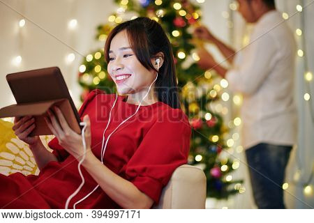 Happy Pretty Young Vietnamese Woman Resting On Sofa And Video Calling Her Friends When Husband Decor
