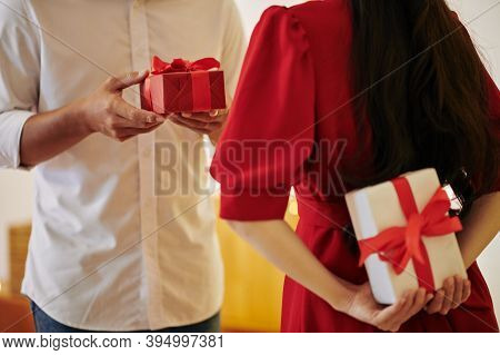 Young Couple Exchanging Romantic Presents On Christmas Eve Or Valentines Day