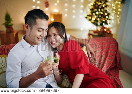 Beautiful Young Asian Couple In Love Spending Christmas Night At Home And Drinking Champagne