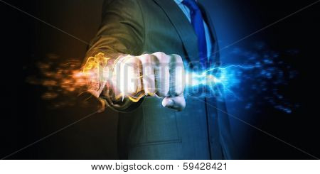 Businessman holding fire flames in fist. Power and control