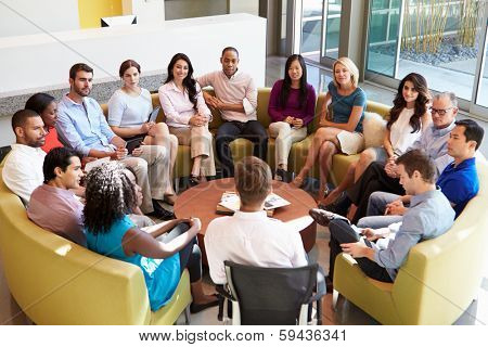 Multi-Cultural Office Staff Sitting Having Meeting Together