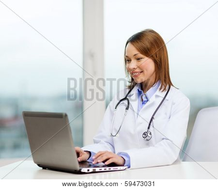 medicine and healthcare concept - busy doctor with laptop computer