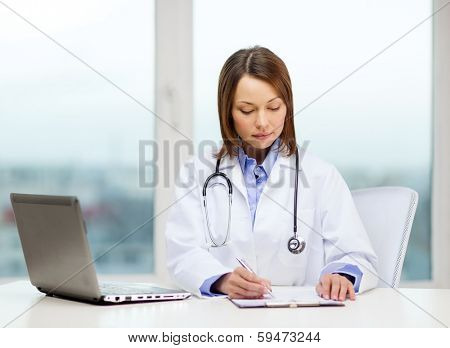 medicine and healthcare concept - busy doctor with laptop computer