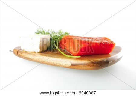 Rose saumon sur une plaque en bois avec du fromage