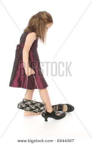 Bambina cercando le scarpe della mamma