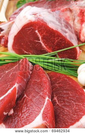 raw meat : fresh beef pork big rib and fillet with garlic and green stuff on wood isolated over white background