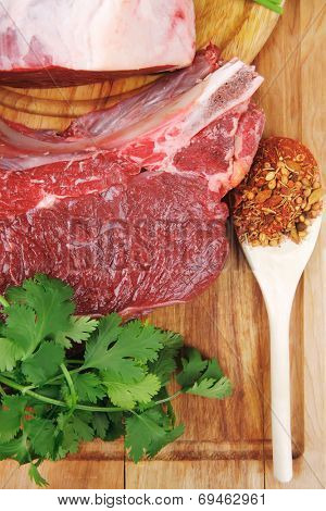 raw meat : fresh beef pork big rib and fillet with garlic and green stuff on wood isolated over white background