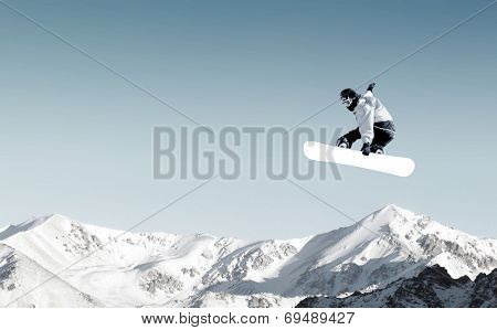 Snowboarder making high jump in clear blue sky