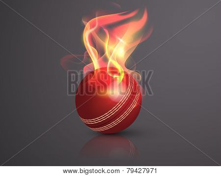 Red cricket ball in flame on glossy grey background.