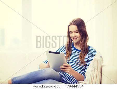 home, technology and internet concept - smiling teenge girl lying on the couch with tablet pc computer at home