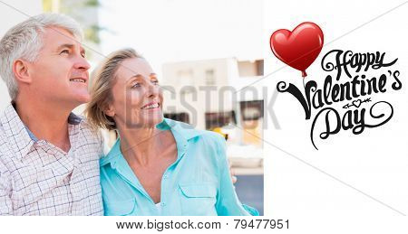 Happy mature couple sitting on bench in the city against cute valentines message