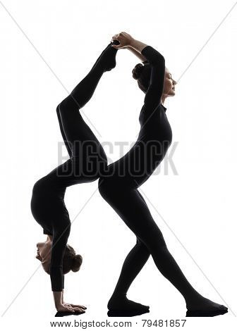 two women contortionist practicing gymnastic yoga in silhouette on white background