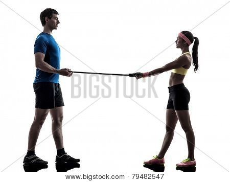 one woman exercising resistance rubber band fitness workout with man coach in silhouette on white background