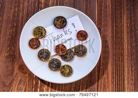 a plate of coins for tips or fee for toilets. in english