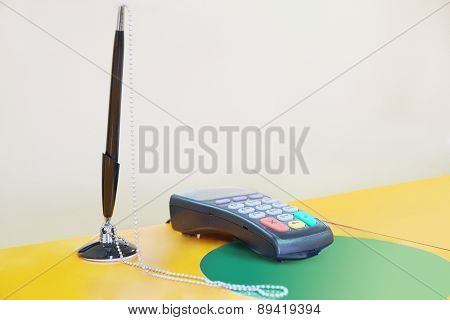 Bank terminal and black pen on the reception desk