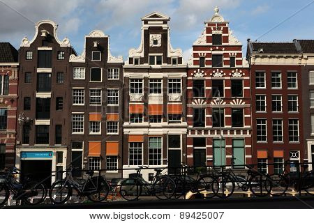 AMSTERDAM, NETHERLANDS - AUGUST 9, 2012: Bicycles parked in front of the traditional Dutch brick houses on Rokin Street in Amsterdam, Netherlands.