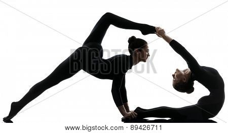 two women contortionist practicing gymnastic yoga in silhouette on white background