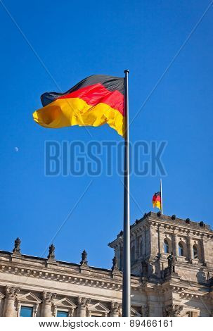 German National Flag Waving In Front Of German Parliament Building In Berlin