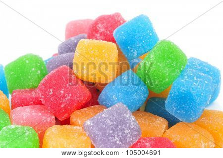 closeup of some cubic gumdrops of different colors on a white background