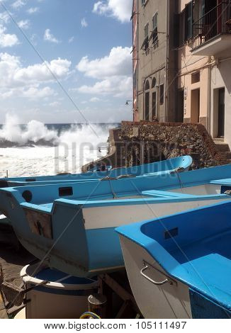 Riomaggiorre Cinque Terre fishing boats on street during raging stormy sea against cliffs