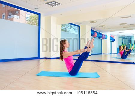 Pilates woman open leg rocker exercise workout at gym indoor
