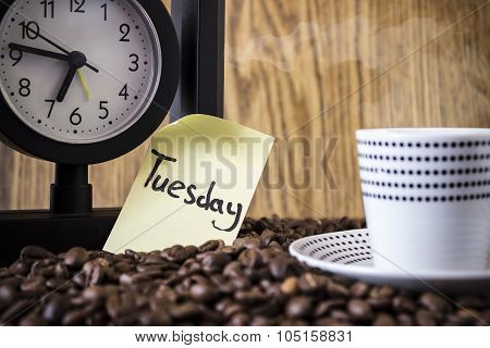 Cup Polka Dots, Clock And A Sticker With The Day Standing On Coffee Beans. Blur, Focus On Sticker