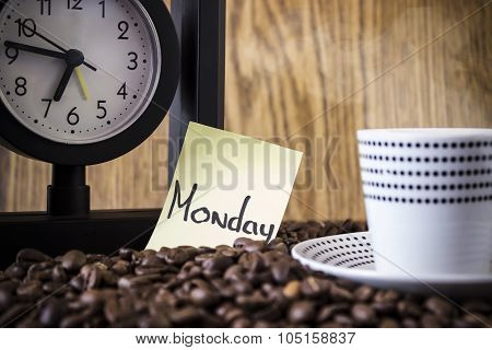 Cup Polka Dots, Clock And A Sticker With The Day Standing On Coffee Beans. Blur, Focus On Sticker