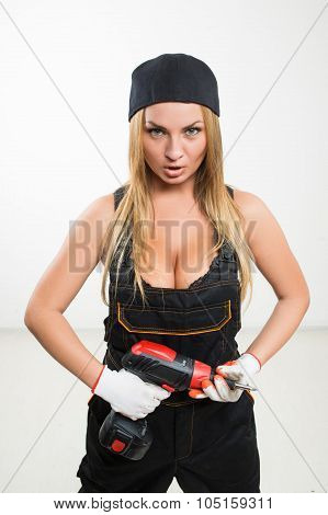 Young sexy female holding a cordless screwdriver
