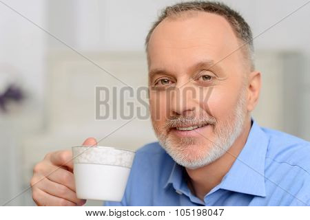 Agreeable man drinking tea.
