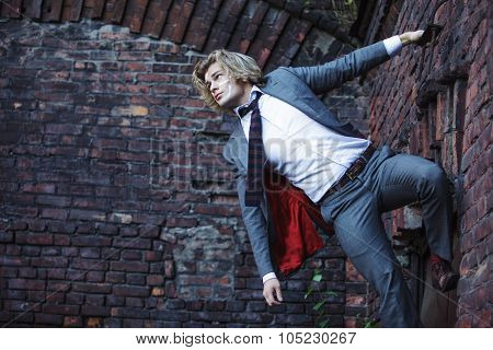 Businessman warrior. Young man  with  war paint on his face climbs up the wall , concept