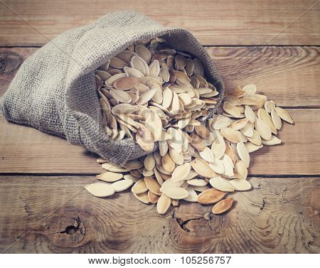 Pumpkin seeds on a wooden background