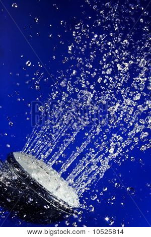 Mano doccia doccia con movimento fermato acqua scende sul profondo blu