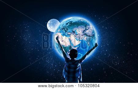 Back view of girl with hands up looking at planets. Elements of this image are furnished by NASA