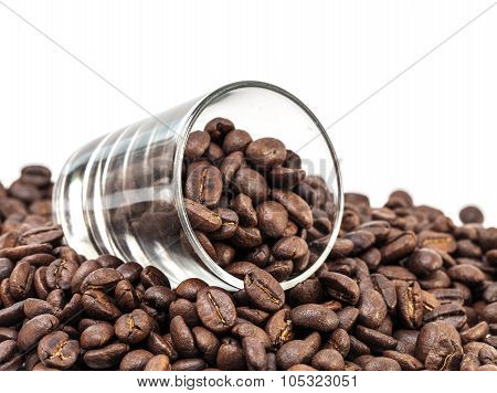 coffee beans pour out from glass shot isolated on white background