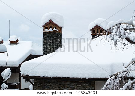 chimney and chalet roof covered with deep snow