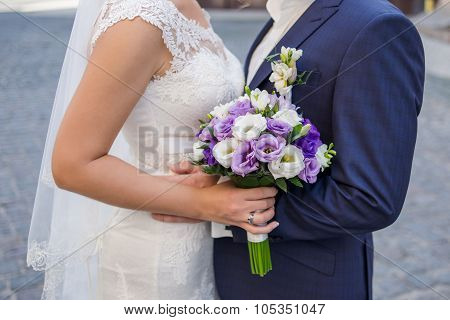 Wedding Bouquet Of Flowers In The Hands Of The Bride And Groom