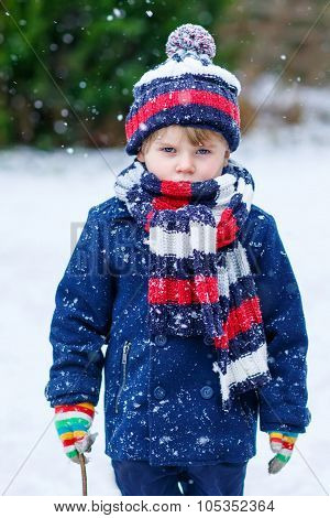 Sad Kid Boy In Colorful Winter Clothes Having Fun With Snow, Outdoors