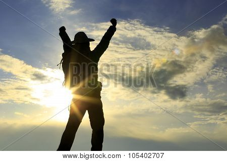 silhouette of backpacker on sunset mountain peak