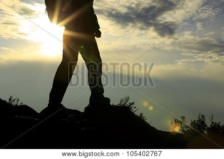 silhouette of backpacker on sunset mountain peak