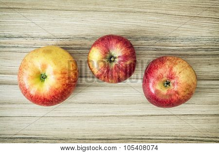 Three Apples On The Wooden Background