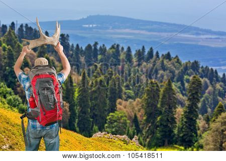 Tourist man with backpack standing with horns