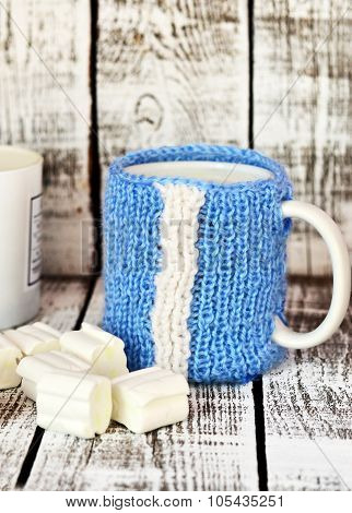 Mug with milk and marsmallow on the white table