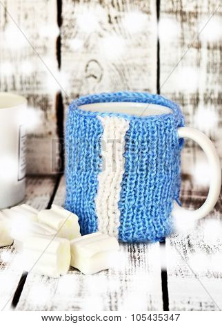 Mug with milk and marsmallow on the white table