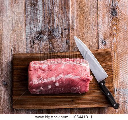 big piece of raw meat on cutting board