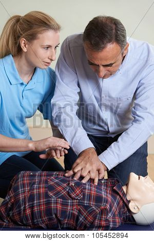 Woman Demonstrating Cpr On Training Dummy In First Aid Class