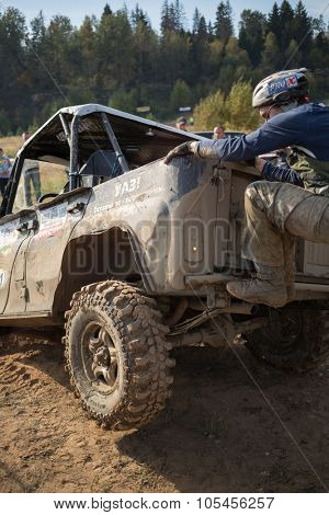 RUSSIA, PUSHKINO -?? 20 SEP, 2014: Rally team member is climbing on off-road vehicle at Rainforest Challenge Russia Autumn 2014 PRO-X.